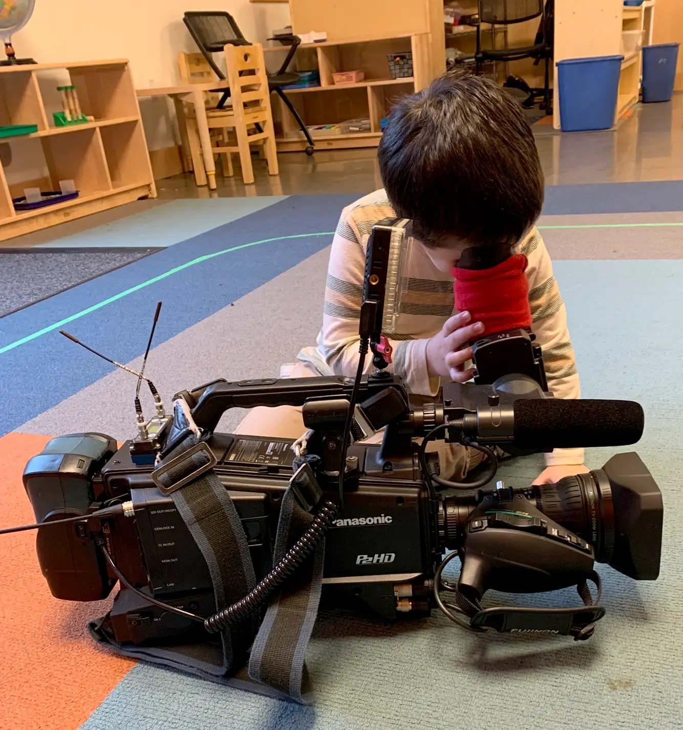 Young boy playing with and studying a video camera